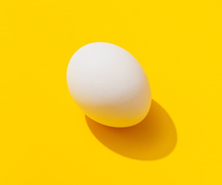 image d'un œuf blanc sur un fond jaune